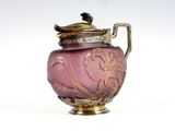 a purple vase with a gold lid on a white surface