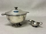 a silver bowl and a silver saucer on a table