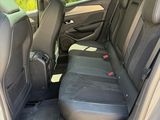 the back seats of a car with the door open and the driver ' s seat folded down