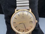 an image of a gold and silver wrist watch on a black pillow