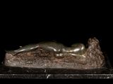 statue of a woman laying on a rock on a black background