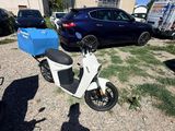 un scooter avec une boîte bleue à l'arrière