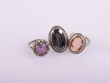 three different colored stone rings sitting on top of each other