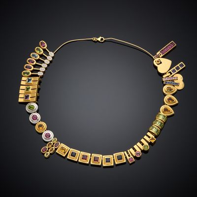 a gold necklace with various colored stones on a black background