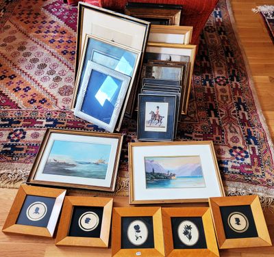 de nombreuses photos encadrées posées par terre dans le salon