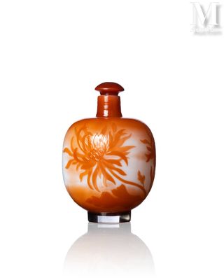un vase orange orné d'une fleur blanche