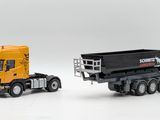 two toy trucks side by side on a white surface