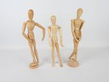 three wooden mannequins standing next to each other