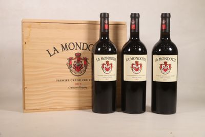 trois bouteilles de vin devant une caisse en bois