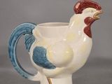 a white cup with a blue and red rooster on it