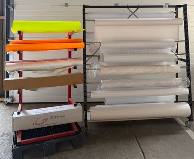 de nombreux rouleaux de papier posés sur un rayonnage dans un entrepôt