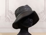 un chapeau noir posé sur la tête d'un mannequin posée sur une table