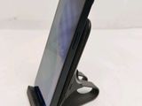 a close up of a cell phone on a stand on a white surface