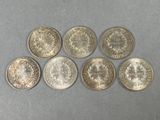 a group of six silver coins sitting on top of a table