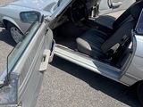 une voiture argentée dont la portière est ouverte sur un parking