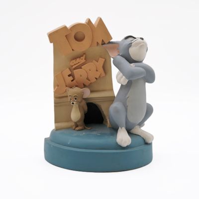a figurine of a cat and mouse in front of a sign
