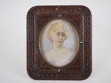 an old picture of a woman in a white dress in a wooden frame