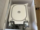 a white toilet with wheels in a box on the floor