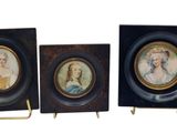 trois portraits miniatures de femmes, encadrés, sont exposés sur un socle