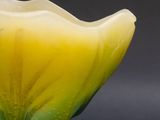 a yellow and green glass bowl on a black surface