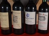 three bottles of red wine are lined up on a table
