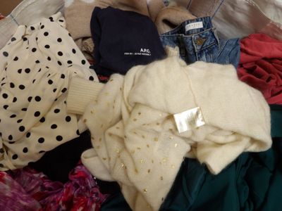 a basket full of clothes and a teddy bear in it