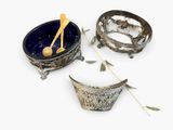three bowls with spoons and spoon rest on a white surface