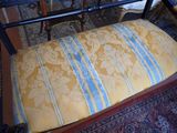 a bench with a cushion on it in front of a rug