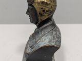 a close up of a bust of a man wearing a helmet on a table