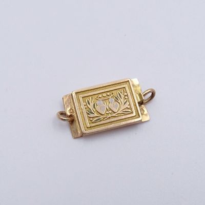 une image représentant un pendentif en forme de livre plaqué or sur un fond blanc