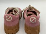 pink and white sneakers with a peace sign on the sole