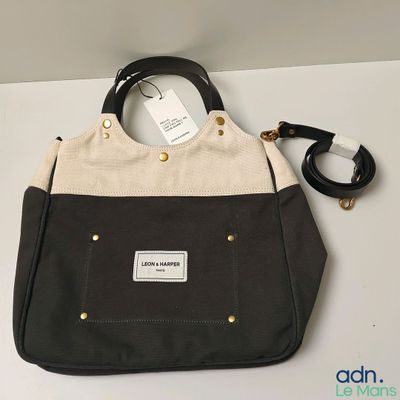 a black and white handbag with a tag on it