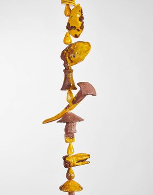 une sculpture composée de différents types d'objets fixés sur un poteau