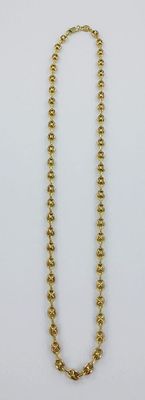 un gros plan d'un collier de perles dorées sur fond blanc