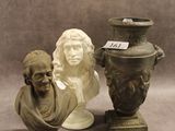 une statue représentant un homme assis à côté d'un vase et un buste d'homme