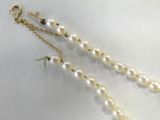 pearl and gold chain necklace with dangling pearls on a white background