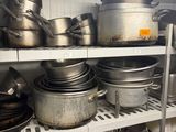 many pots and pans on the shelves in the kitchen