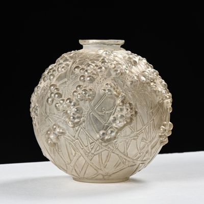 un vase blanc posé sur une table sur fond noir