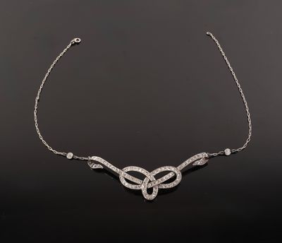 a white gold and diamond necklace on a black background