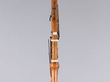 a wooden clarinet on a clear stand with a white background