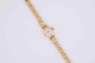a close up of a gold watch on a white surface