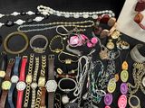 many different types of jewelry on a black table