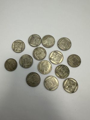 a pile of silver coins sitting on top of a white surface