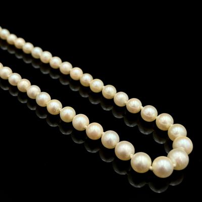 gros plan d'un collier de perles sur une surface noire