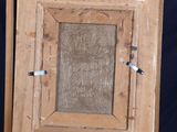 an old wooden easel with a painting on it against a blue background