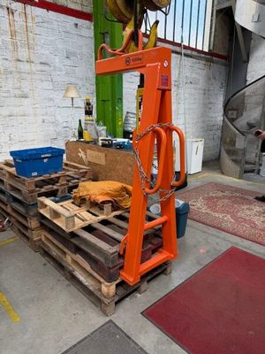 un homme debout à côté d'une pile de palettes dans un entrepôt