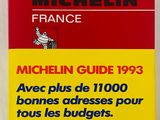 un livre rouge posé sur une table blanche, à côté d'un livre rouge et jaune