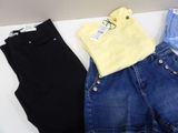 three pairs of jeans and a yellow shirt are sitting on a table