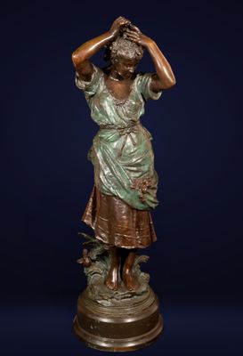 a bronze statue of a woman with a bird on her head