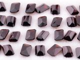 un gros plan sur un bouquet de perles de verre marron posées sur une surface blanche